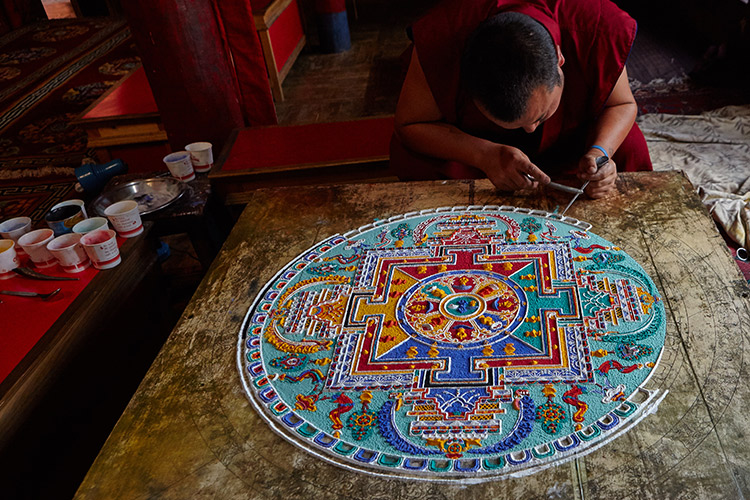 Tibetan monk constructing a sand mandala. Source: Invaluable.com